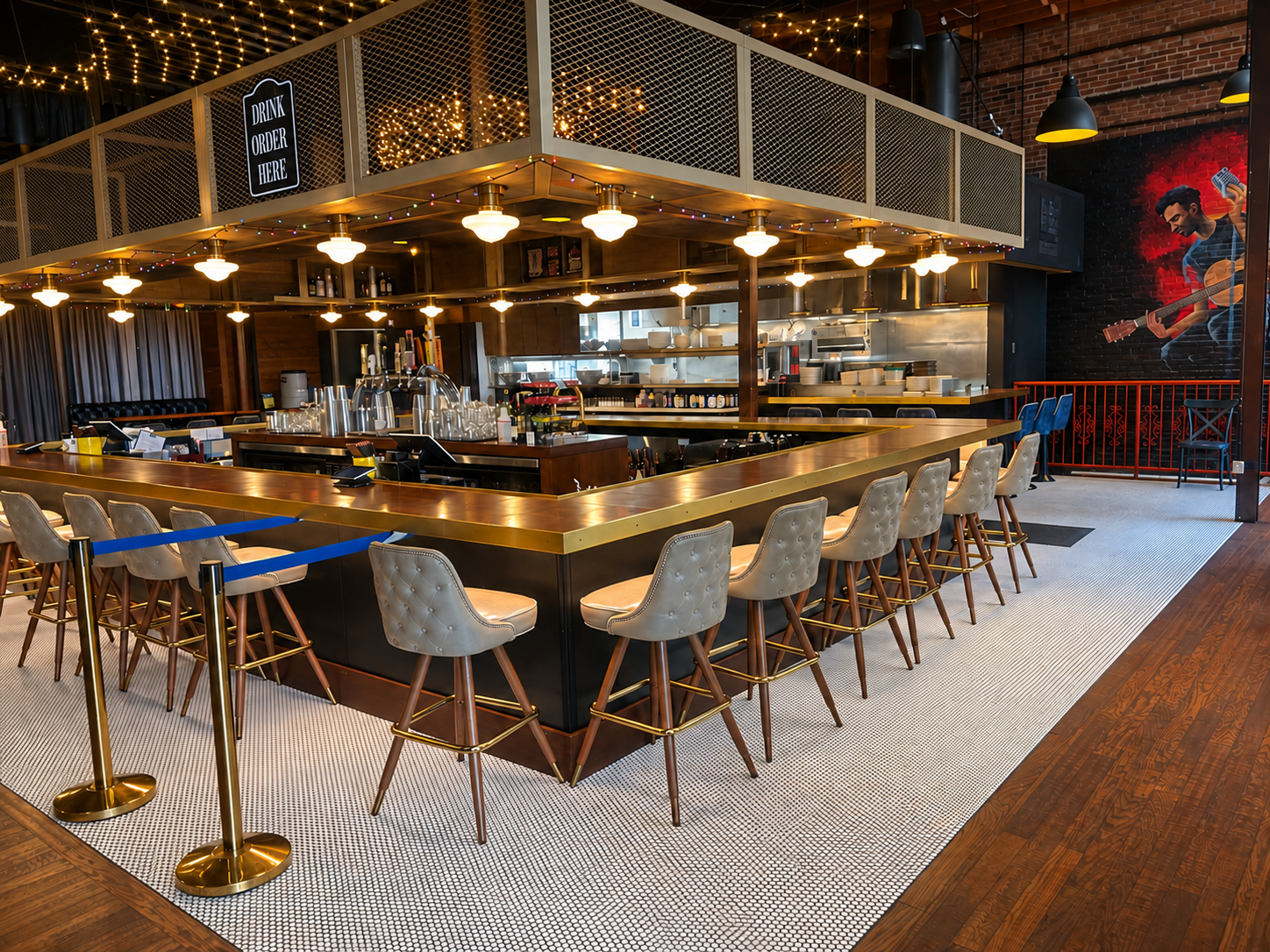 Publick House bar with brass edging, upholstered stools, and warm string lights